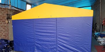 Blue and yellow tent set up indoors in a garage or workshop.
