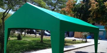 Green outdoor canopy tent set up on a sunny day.