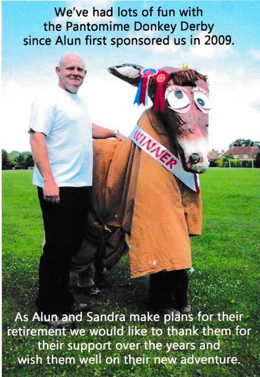 Man with a person in a donkey costume celebrating a Pantomime Donkey Derby win.