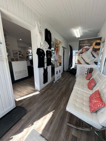 Cozy salon waiting area with white couch and promotional displays.