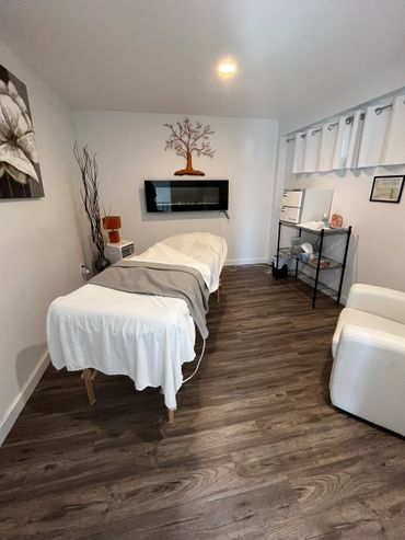 Cozy massage therapy room with a treatment table and calming decor.