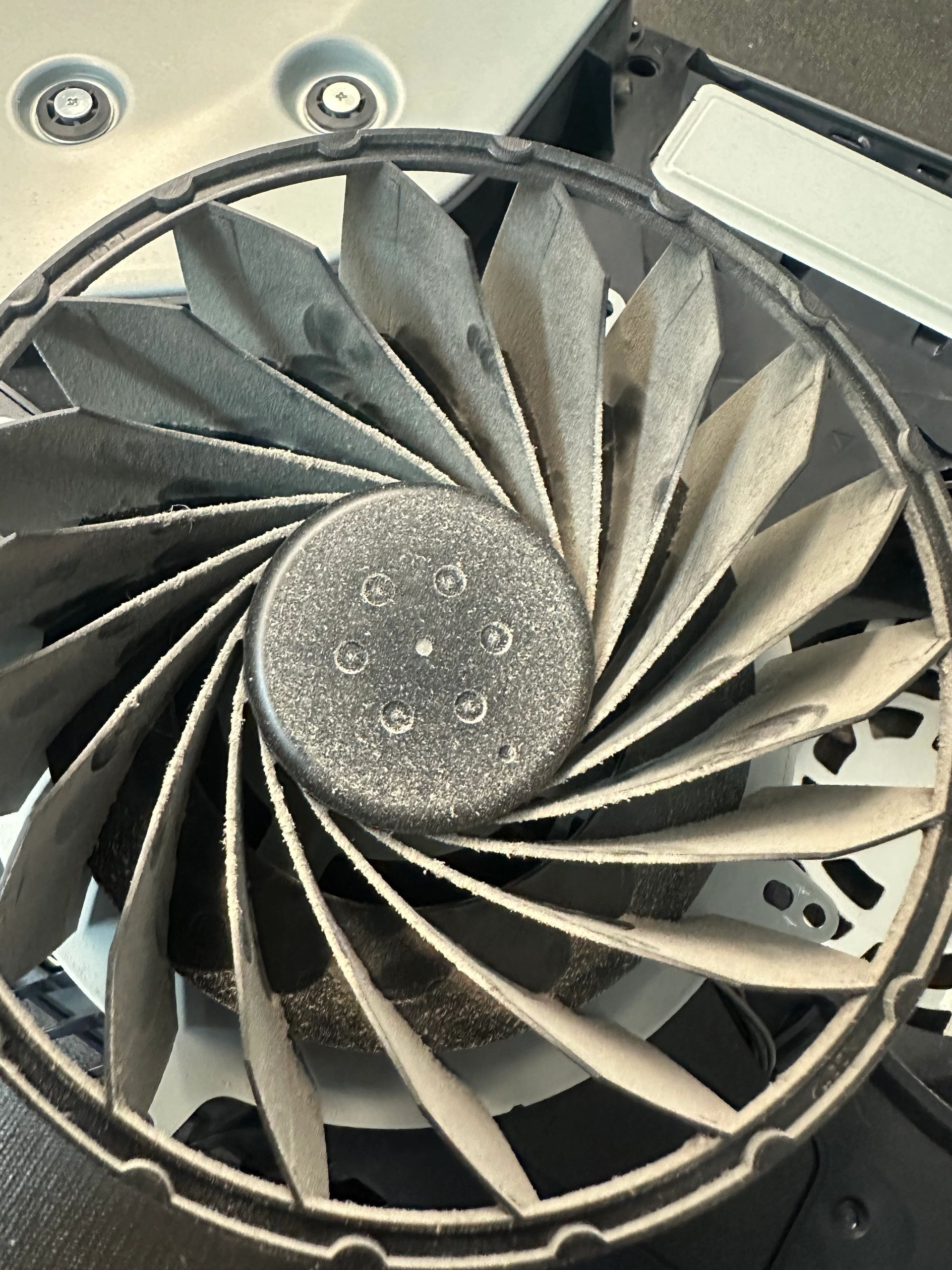 Close-up of a computer cooling fan with dust buildup.