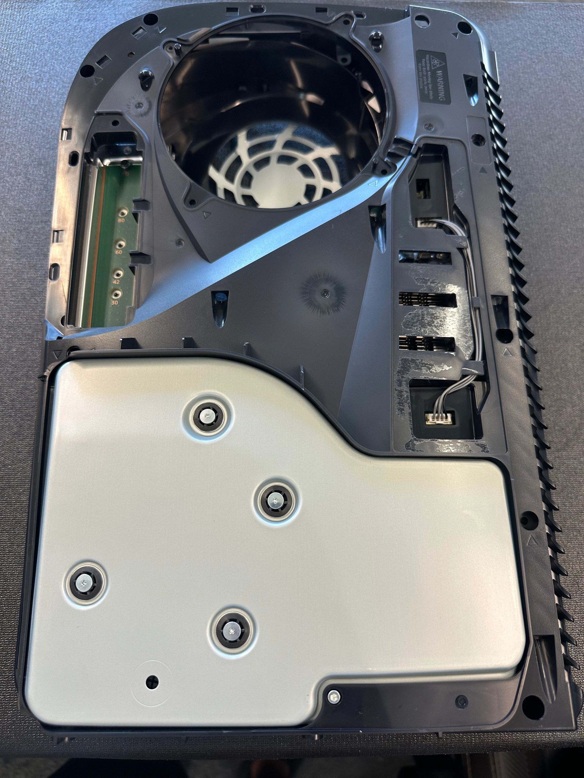 Interior of a black electronic device with exposed components.