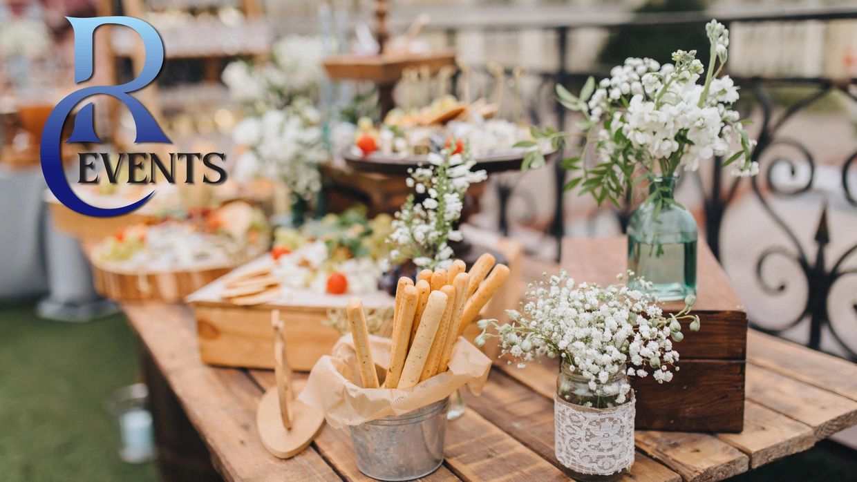 Rustic event table with snacks and floral decorations.