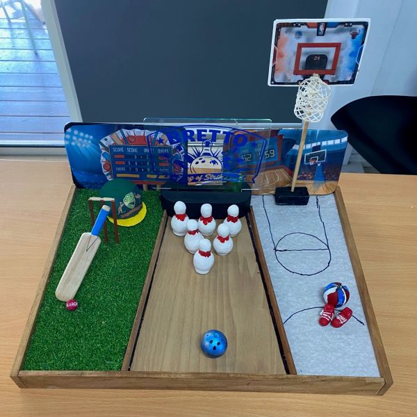 Miniature sports-themed board with cricket, bowling, and basketball sections.