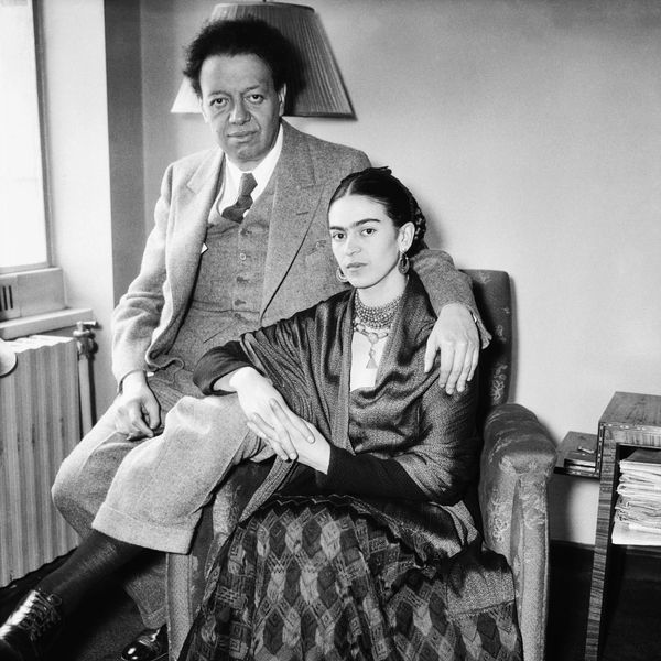 Black and white photo of a man and woman seated closely together indoors.