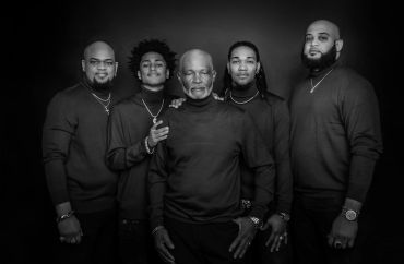 Five men in black turtlenecks posing together in a monochrome family portrait photo.Taisha Marie Photos , Bronx, NY, New York City
