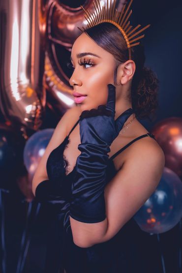 sexy birthday photoshoot portrait with balloons, satin gloves, and crown