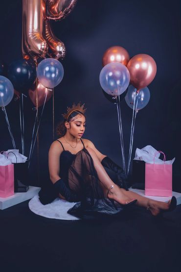 birthday photoshoot portrait with balloons, satin gloves, and crown