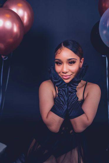 birthday photoshoot portrait with balloons, satin gloves, and crown