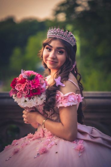 Quinceañera in elegant gown, smiling