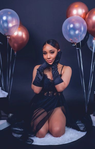 birthday photoshoot portrait with balloons, satin gloves, and crown