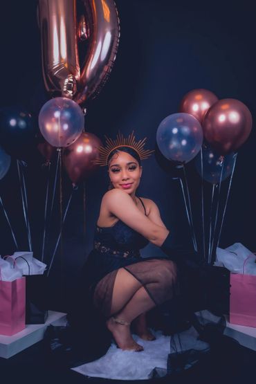 birthday photoshoot portrait with balloons, satin gloves, and crown