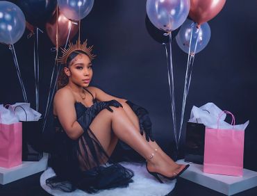 birthday photoshoot portrait with balloons, satin gloves, and crown