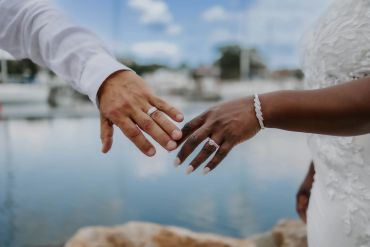 Close-up of a couples hands with wedding rings near water. in glen island, New Rochelle. Taisha Marie Photos , Bronx, NY, New York City