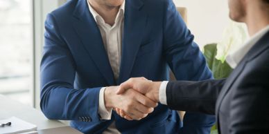 Two men shaking hands in a business setting.