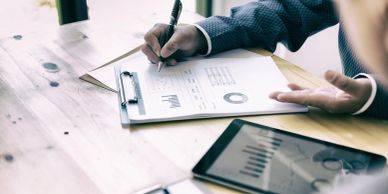Person analyzing graphs and charts with pen and tablet.