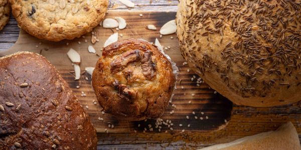 Various baked goods and nuts on a wooden board.