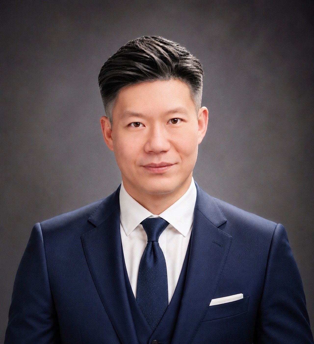 Professional headshot of a man in a navy suit and tie.