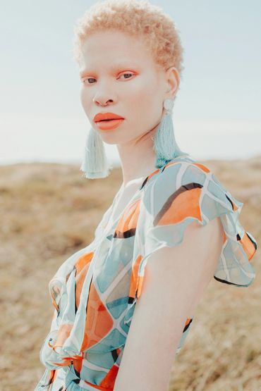 Editorial makeup look in tones of orange , blue and white