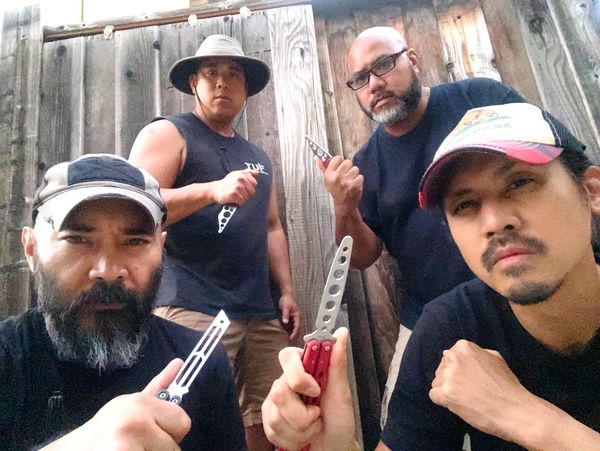 A group picture of men with pocket knives