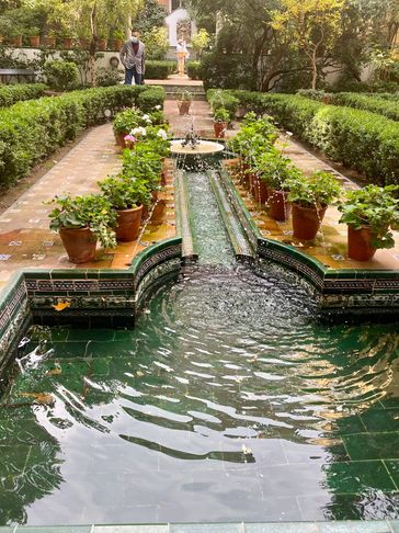 Formal fountain with potted plants