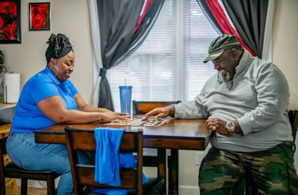 Two people playing a board game and enjoying themselves at a dining table.