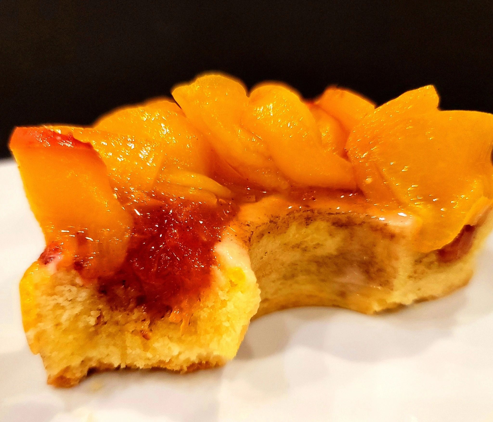 Peach Frangipane Cake in a shortbread tart, topped with a fresh peach compote and garnished with rib