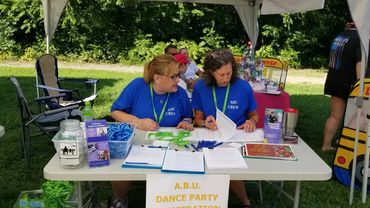 Board Members Randi Rue Power and Melinda Smyth register attendees to the A.B.U. Summer Dance Party.