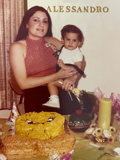 Woman hold the child on the hand in front of cake