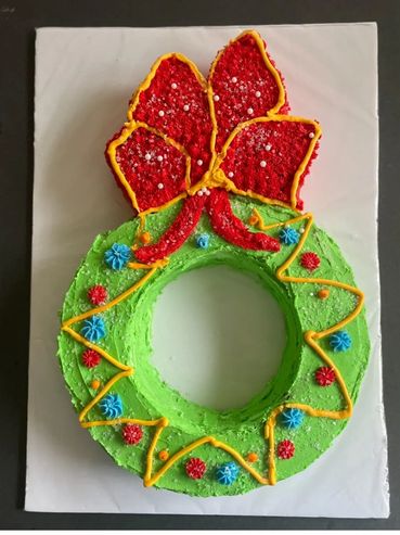 Moist Christmas tree cake decorated with red icing & colorful sprinkles for holidays.

