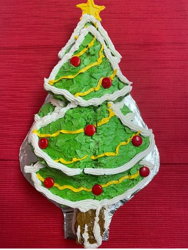 Homemade Christmas tree cake with buttercream frosting & star-shaped candy topper.

