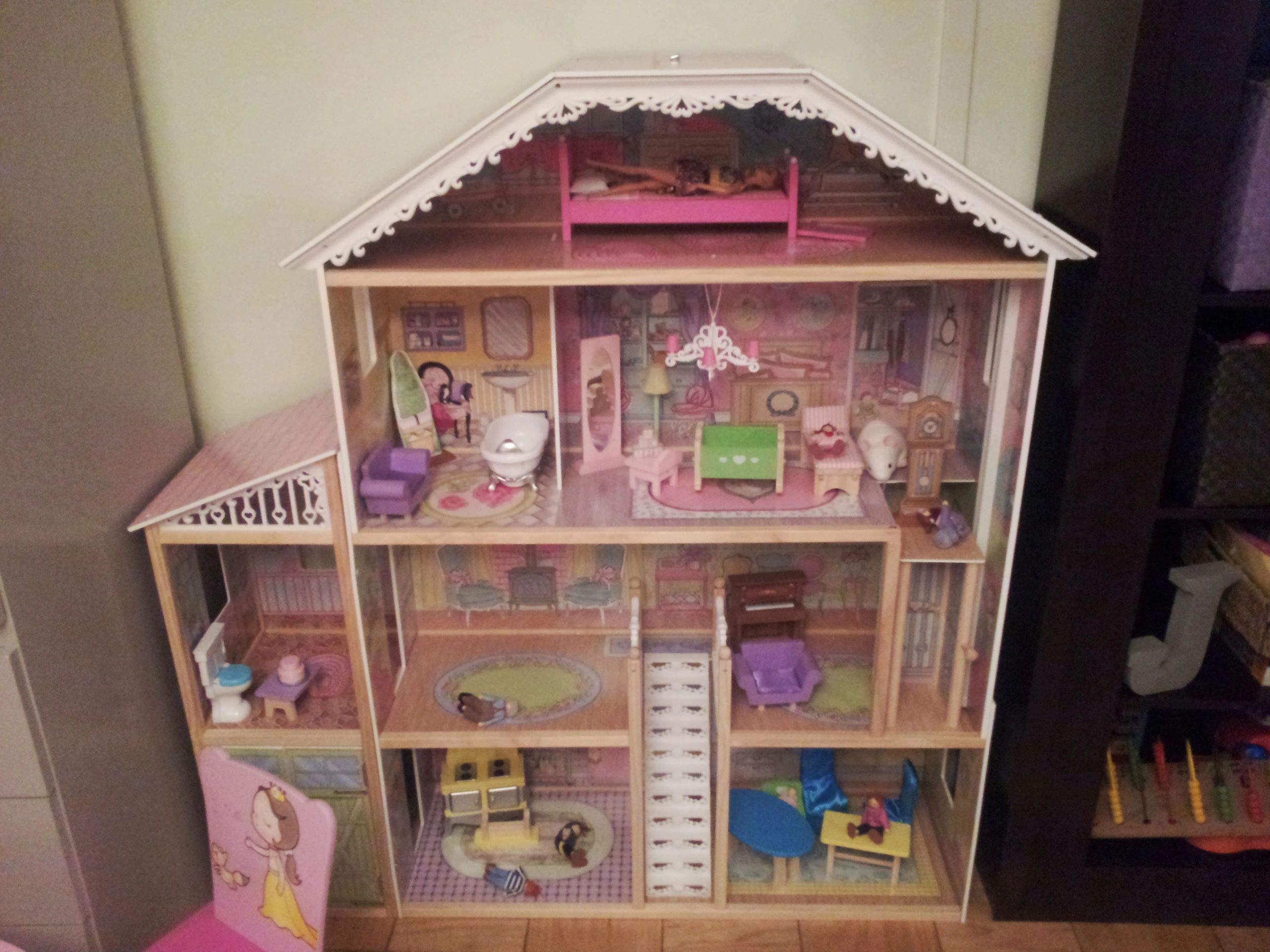 Detailed wooden dollhouse with multiple floors and furniture.