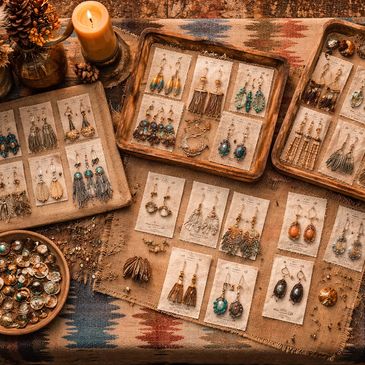 Bohemian-style earrings displayed on rustic trays with warm autumn decor.