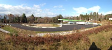 A gas station in a rural setting on a sunny day.