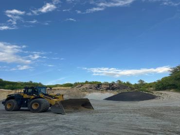 Bulldozer on a sandy terrain under a blue sky.