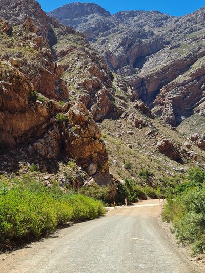 Winding dirt road through rocky mountainous terrain.