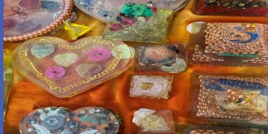 Various colorful resin art pieces on an orange surface.