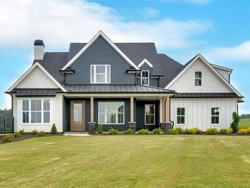 Large modern farmhouse with gray and white exterior.