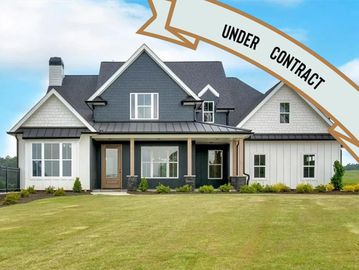Large modern farmhouse with gray and white exterior.