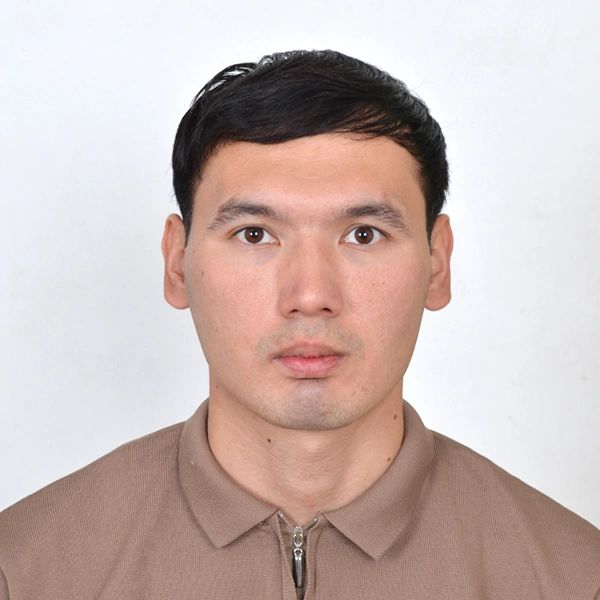 Portrait of a young man with short black hair wearing a brown zip-up shirt.