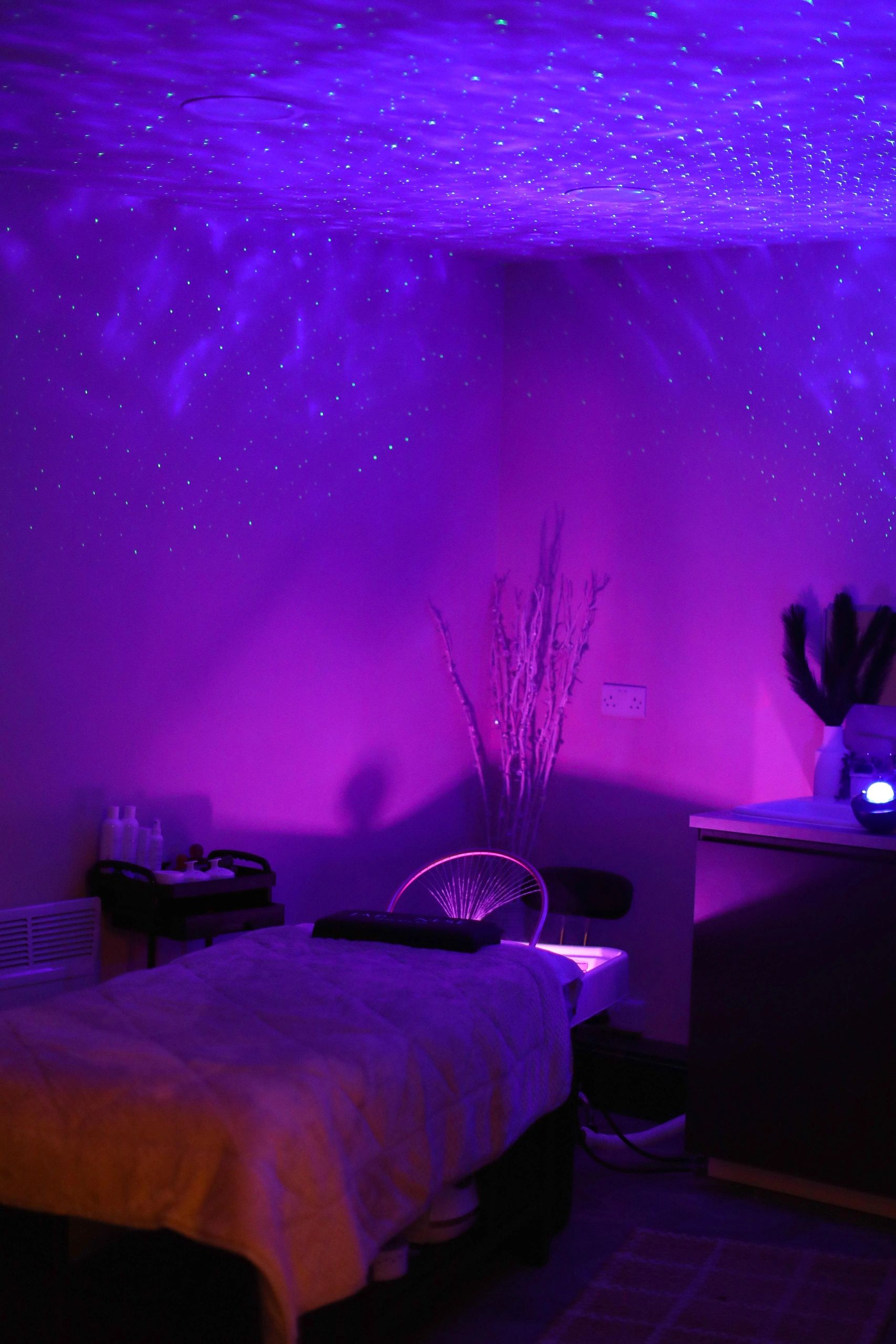 Dim room with purple ambient lighting and star-like dots on the ceiling.