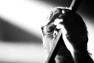 Black and white close-up of a musician playing guitar.