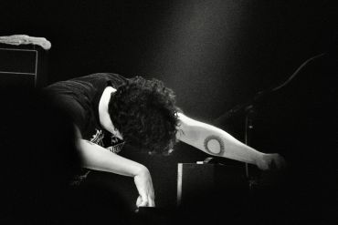 Performer bowing on stage during a concert.