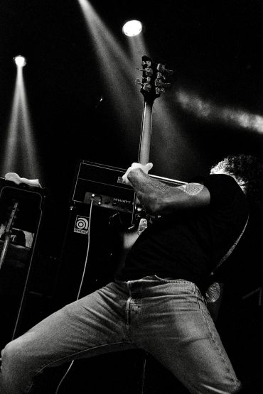 Musician passionately playing an electric guitar on stage.
