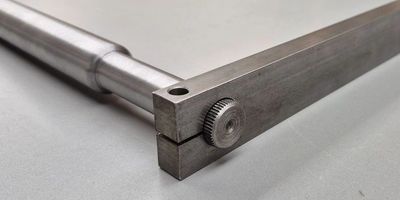 Close-up of a metal caliper tool on a white surface.