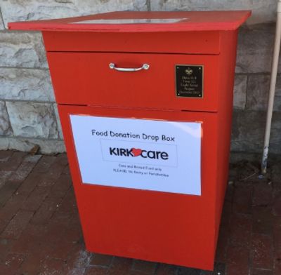 Red food donation drop box labeled for Kirk Care charity.