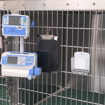 Medical infusion pumps attached to a metal cage with a clipboard.