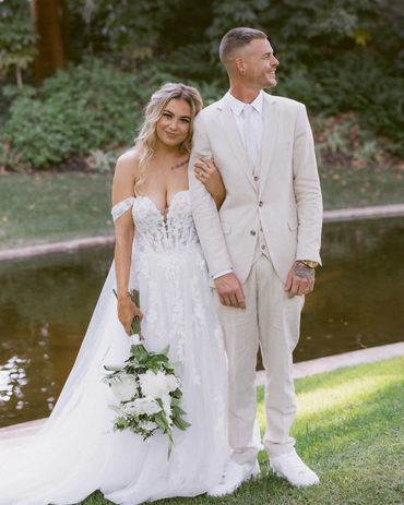 Bride and groom posing outdoors on their wedding day.