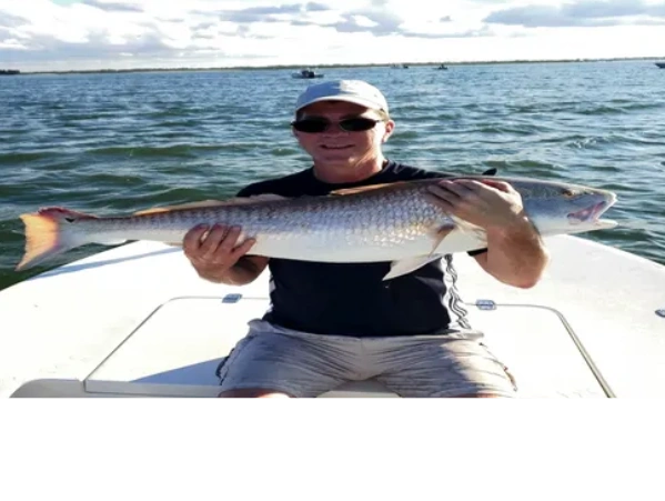 client with a redfish he caught while inshore fishing